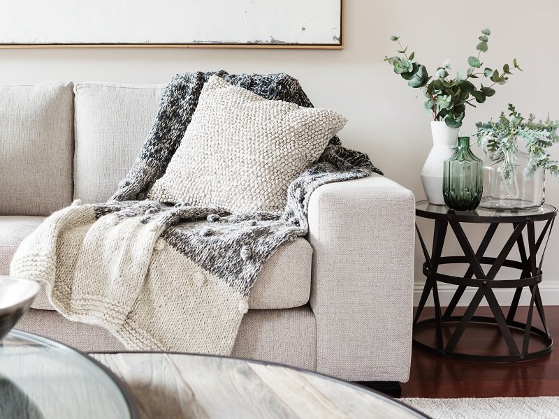 Sofa mit hellen Kissen und Decken.