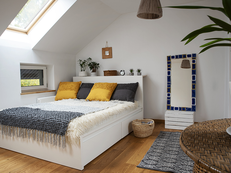 Nachhaltig eingerichtetes Schlafzimmer mit Kissen in grau und gelb - Pantone Trendfarben 2021