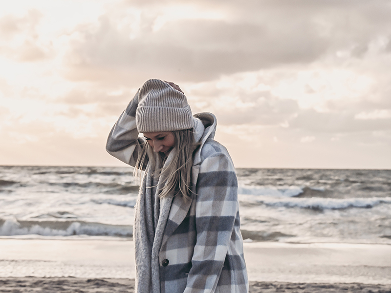 Instagram Interior Account: Bloggerin sardoe mit Jacke und Mütze am Strand