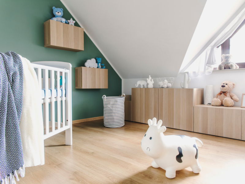 Babybett im Zimmer mit Schraegen als Möbel Haengeboards und Lowboards