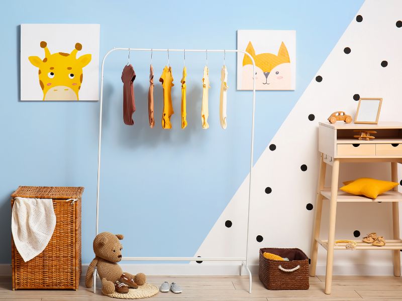 Kleiderstange im Babyzimmer mit farbenfrohen Dekoelementen